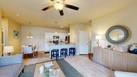 Located at 2605 Sidbury Crossing Dr in Castle Hayne, NC, this single-floor, 2-bedroom, 2-bathroom home offers a thoughtfully designed open-concept layout. The living, dining, and kitchen areas flow seamlessly together, anchored by a generous kitchen featuring white shaker cabinetry, granite countertops, a large peninsula with bar seating, pendant lighting, and stainless steel appliances including a refrigerator, range, and microwave. The adjacent dining nook is illuminated by a chandelier and provides a cozy setting for everyday meals. The living room is bright and comfortable, with plush carpet, a ceiling fan, and neutral walls that create a relaxed ambiance. Both bedrooms are well-sized, carpeted, and fitted with ceiling fans and windows that allow natural light to fill each room. The primary bedroom offers a notably comfortable retreat with closet access. Both bathrooms are finished with tile flooring, white vanities with ample storage, and clean, classic fixtures. A dedicated laundry area adds everyday convenience. The home also includes two closets for additional storage. Throughout, the warm neutral palette and consistent finishes give the space a cohesive, move-in-ready feel.