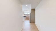 Located in Lynnwood, Washington, this well-designed 2-bedroom, 2-bathroom residence offers a clean, modern aesthetic across a single floor. Light wood-tone flooring flows consistently throughout every room, creating a warm and cohesive feel.

The kitchen is a standout feature, showcasing flat-panel cabinetry in a soft wood finish, bright white quartz countertops, a central island with pendant lighting, stainless steel appliances including a range, microwave, dishwasher, and refrigerator, and a window that brings in natural light.

The living area is open and airy, illuminated by a stylish circular pendant light and a large window with a balcony view of the surrounding Lynnwood cityscape. The two bedrooms are bright and well-proportioned, with one featuring a sleek barn-style sliding door leading to a dedicated walk-in closet outfitted with wire shelving. The primary bedroom includes a natural light source via a side window.

Both bathrooms continue the clean design language, with one featuring a full soaking tub and shower combo with brushed nickel fixtures and a curved curtain rod. The second bathroom offers a vanity with warm-toned cabinetry. A hallway connects the rooms efficiently, completing this thoughtfully laid-out residence.