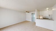 Located at 20939 Parthenia St in Canoga Park, CA, this single-story unit offers a thoughtfully arranged floor plan encompassing one bedroom, one bathroom, a kitchen, and a dedicated closet. The overall layout is compact yet functional, making efficient use of its available space.

The galley-style kitchen features granite-look countertops, white cabinetry with ample upper and lower storage, a stainless steel double sink, a refrigerator, and an electric range with hood ventilation. Wood-look flooring adds warmth and durability to the kitchen area.

The living area connects directly to the kitchen and is finished with neutral carpet and a ceiling fan, lending a comfortable, casual atmosphere. The bedroom is carpeted and receives natural light through a window fitted with vertical blinds. A textured ceiling is present throughout. A dedicated walk-in closet off the bedroom provides generous storage, featuring wrap-around hanging rods and carpeted flooring.

The bathroom includes a vanity with granite-look countertops, white cabinetry, a large mirror, a wall-mounted light fixture, and wood-look flooring, maintaining a clean and cohesive aesthetic consistent with the rest of the unit.