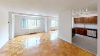 This single-floor residence offers a thoughtfully designed layout that balances open living spaces with functional details throughout. The polished parquet wood flooring is a defining characteristic, running seamlessly through the living, dining, and bedroom areas, adding warmth and timeless charm to the interior.

The kitchen is well-equipped and modern, featuring rich dark wood cabinetry, granite countertops, a subway tile backsplash, and a full suite of stainless steel appliances including a refrigerator, dishwasher, and gas cooktop. A pendant light fixture adds a stylish touch, while an island with a built-in gas range provides added prep space and a natural connection to the main living area.

The living and dining spaces are generously proportioned, bathed in natural light from multiple windows that frame lush, tree-lined outdoor views. The bright, neutral white walls create a clean and versatile backdrop throughout.

The bedroom is well-sized and includes a dedicated walk-in closet, offering ample storage. The bathroom is finished with tasteful granite countertops, an undermount sink, and neutral tile flooring, contributing to the home's consistent, refined aesthetic. The overall layout, as seen in the dollhouse view, is efficient and open, creating a comfortable and inviting living environment.