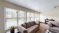 This two-floor residence offers a practical and well-organized layout designed for comfortable everyday living. The kitchen is equipped with light maple cabinetry providing ample upper and lower storage, light-toned countertops, a double sink, an electric range, a dishwasher, and a refrigerator. Wood-look flooring runs throughout the kitchen, creating a clean transition from the adjacent living area. The spacious living room features wall-to-wall carpeting, a textured ceiling, and a window that allows natural light to fill the room. The open sightline between the living area and kitchen enhances the sense of space throughout the main level. The bedrooms are carpeted and well-lit, each featuring baseboard heating and windows fitted with blinds that bring in natural light and outdoor views. Two bathrooms serve the residence — one with a tub and shower combination, vanity, and wood-look flooring, and a second half bath with a vanity and mirror. A dedicated laundry room with overhead shelving and wood-look flooring adds everyday convenience. Throughout the space, neutral wall tones and consistent flooring materials create a cohesive and functional living environment across both floors.