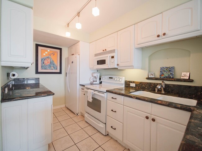 Full kitchen with pans, plates, and dinnerware. - 130 Padre Blvd