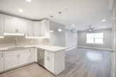 Located at 77 S Tyson Ave in Floral Park, NY, this thoughtfully renovated single-floor unit offers a clean, modern aesthetic with high-quality finishes throughout. The open-concept layout seamlessly connects the kitchen and living area, creating a bright and airy atmosphere ideal for everyday living and entertaining.

The kitchen is a standout feature, showcasing white shaker-style cabinetry with brushed nickel hardware, light marble-look quartz countertops, a subway tile backsplash with under-cabinet lighting, and stainless steel appliances including a range and microwave. Pendant lighting and a peninsula with additional counter space enhance both function and style.

The spacious living area is finished with light hardwood-style flooring, crown molding, recessed lighting, and a modern ceiling fan. A wall-mounted mini-split unit provides efficient climate control, and a window allows natural light to fill the room. An electrical panel is conveniently integrated into the space.

The bedroom is generously sized, featuring crown molding, a ceiling fan, recessed lighting, and access to a well-organized walk-in closet with built-in shelving. The bathroom is elegantly appointed with a white vanity, framed mirror, tiled tub/shower combination with glass enclosure, and neutral tile flooring, completing this move-in-ready unit.