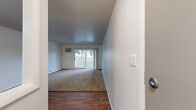 Located at 8580 100th Terrace in Palos Hills, IL, this single-floor, one-bedroom, one-bathroom unit offers a practical and comfortable layout. The living room is a bright, open space featuring warm wood-look flooring, plush carpeting, a ceiling fan with light fixture, and a sliding glass door that opens to an outdoor balcony area, allowing natural light and outdoor views to flow in. Adjacent to the living room, the galley-style kitchen is efficiently designed with white quartz countertops, gray shaker-style cabinetry on both sides, stainless steel appliances including a refrigerator, gas range, and dishwasher, as well as a single-basin sink — maximizing both function and style. The spacious bedroom features soft carpeting, a window with a view of the surrounding greenery, a baseboard heating unit, and notably two side-by-side louvered bifold closets, providing generous storage. The full bathroom is clean and modern, finished with white tile surrounds in the tub and shower area, a vanity with a white countertop and brushed nickel fixtures, a large mirror, and wood-look flooring. The unit's neutral palette and thoughtful layout make it a functional and inviting living space throughout.