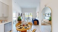 Located at 1472 NW 36th St in Miami, FL, this well-appointed two-bedroom, two-bathroom residence offers a thoughtfully designed open-concept layout with modern finishes throughout. Light wood-tone flooring flows seamlessly across the entire unit, complemented by crisp white walls and soaring ceilings that enhance the sense of space and airiness.

The living and dining area anchors the main living space, bathed in natural light from a sliding glass door that opens directly onto a private balcony — ideal for outdoor dining or relaxing with views of the surrounding landscape. The kitchen features floor-to-ceiling light wood cabinetry, white quartz countertops, and a full suite of stainless steel appliances including a refrigerator, range, over-the-range microwave, and dishwasher.

The primary bedroom is generously proportioned, with large windows that invite abundant natural light and direct balcony access. The second bedroom is equally bright, with high ceilings and a dedicated closet. Both bathrooms are finished with light wood vanities and white countertops; one includes a tub-shower combination with tile surround. Additional conveniences include in-unit laundry, two closets, and hallway access connecting all areas of the home efficiently.