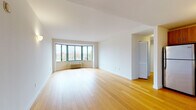 Located at 550 Locust St in Mount Vernon, NY, this thoughtfully designed residence offers a clean, modern aesthetic throughout its single-floor layout. The spacious living area is a standout feature, showcasing warm hardwood flooring and a large bay window that floods the space with natural light while framing elevated views of the neighborhood's tree-lined surroundings. An additional windowed nook extends the living area, offering even more light and outdoor perspectives.

The kitchen is well-equipped with warm wood cabinetry extending to the ceiling, a white subway tile backsplash, and a full suite of stainless steel appliances including a range, over-the-range microwave, and dishwasher, all set atop matching hardwood flooring.

The bedrooms are carpeted for comfort and include windows with neighborhood views, individual climate control units, and ample closet space — one bedroom features a built-in sliding-door closet with shelving. The layout also includes two bathrooms: one featuring a soaking tub with full tile surround and a pedestal sink, and a second with a walk-in tiled shower, wood-toned vanity, and large wall mirror. The overall ambiance is bright, neutral, and move-in ready.