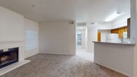 This single-floor residence offers a thoughtfully designed layout that balances comfort and functionality throughout. The main living area welcomes you with plush carpeting, a tiled entryway, and a striking fireplace framed by a clean white mantel, creating a warm focal point in the room. Natural light filters in through blinded windows, lending the space a bright and airy feel. A pass-through counter connects the living area to the kitchen, which is outfitted with warm oak cabinetry, light-toned countertops, a full suite of white appliances including a refrigerator, range, microwave, and dishwasher, and easy-to-clean tile flooring. A hallway leads to the sleeping quarters, where each bedroom features soft carpeting, ceiling fans with light fixtures, and windows with natural light. One bedroom offers a notably generous footprint, while a second provides a quieter, cozier space. Both full bathrooms are finished with tile flooring, warm wood vanities topped with speckled counters, and tub-shower combinations. Throughout the residence, neutral tones and consistent finishes create a cohesive, move-in-ready atmosphere suitable for a variety of living arrangements.
