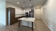 Located at 2157 E Apache Blvd in Tempe, AZ, this 900-square-foot, one-bedroom, one-bathroom apartment delivers a clean, modern aesthetic throughout its single-floor layout. The open-concept kitchen and living room serve as the heart of the unit, featuring luxury vinyl plank flooring, neutral gray walls, and recessed lighting. The kitchen is appointed with two-tone cabinetry — white upper cabinets paired with dark wood-grain lower cabinets — granite countertops, a center island with a built-in sink, stainless steel appliances, and stylish pendant lighting. The living room offers generous space, a ceiling fan, and a sliding glass door that opens to an outdoor view of the surrounding community. The 170-square-foot bedroom includes dual windows with blinds that invite abundant natural light, a ceiling fan, and direct access to a well-sized walk-in closet with built-in shelving and hanging rods. The bathroom features wood-grain luxury vinyl flooring, a soaking tub with a subway-tiled shower surround, a dark wood vanity with white countertop, and a large mirror. A hallway connects all rooms efficiently, completing this well-appointed Tempe residence.