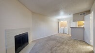 Located at 8711 Cinnamon Creek Dr in San Antonio, TX, this two-story home offers a practical and comfortable layout across two equally sized floors. The main level welcomes you with a carpeted living room featuring a tile-surround wood-burning fireplace and a window that fills the space with natural light. Adjacent to the living area is a galley-style kitchen equipped with warm wood cabinetry, dark countertops, tile flooring, and white appliances including a range, refrigerator, and dishwasher. A dedicated in-unit laundry area is conveniently accessible from the main living space. A half bath with a sloped ceiling adds functionality to the lower level. Upstairs, the generously sized primary bedroom offers plush carpeting, a ceiling fan with light fixture, and access to a dedicated closet. The upper-level bathroom includes a full tub-shower combination with classic white tile surround and wood-look flooring. A second living area on the upper floor provides additional flexible space. Textured ceilings and neutral tones throughout the home create a clean, understated aesthetic, while the two-staircase layout enhances the overall flow and accessibility of the space.
