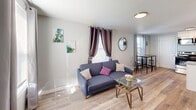 Located at 1603 Roane St in Richmond, VA, this two-floor home offers a thoughtfully updated interior with a clean, modern aesthetic throughout. Light gray walls, light wood-tone flooring, and abundant natural light from multiple windows create a warm and inviting atmosphere across both levels.

The living room provides a comfortable gathering space, furnished with a gray sofa, glass-top coffee table, and decorative artwork. Stylish curtains frame the windows, allowing ample natural light to fill the room while adding a touch of personality to the space.

The kitchen is a functional highlight of the home, featuring granite countertops, crisp white cabinetry, and a full suite of stainless steel appliances including a refrigerator, range with over-the-range microwave, and dishwasher. A peninsula counter offers additional prep space and a casual dining option.

The bedrooms are well-proportioned and bright, each offering natural light through windows dressed with curtains. The upper-floor bedrooms feature vaulted ceilings that add architectural interest and a sense of openness. Each room includes closet access, making for practical and comfortable living.

The bathroom is neatly appointed with a tub-shower combination and clean, neutral finishes. Throughout the home, the consistent use of updated materials and finishes reflects a carefully maintained and move-in-ready property.