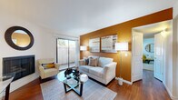 This well-appointed 2-bedroom, 1-bathroom residence in Rocklin, CA offers a comfortable and thoughtfully designed single-floor layout. The living room makes an immediate impression with rich hardwood flooring, a striking warm-toned accent wall, and a sliding glass door that opens to a private outdoor patio, allowing natural light to fill the space. The kitchen is equipped with stainless steel appliances, including a full-size refrigerator and dishwasher, complemented by white cabinetry and granite-style countertops — a clean, functional design that flows naturally into the adjacent dining area. The dining space accommodates a round glass table beneath a ceiling fan, creating an intimate spot for meals. Both bedrooms feature plush carpeting and windows that bring in natural light; the primary bedroom includes a sliding-door closet, while the secondary bedroom offers room for a bed and a small workspace. The full bathroom is finished in crisp white tones with a tub-shower combination, a granite-topped vanity, and hardwood flooring extending through the entryway. Throughout the residence, a cohesive and neutral palette creates a calm, inviting ambiance suited for everyday comfort.