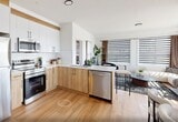 Located in Edmonton's southwest community, this well-appointed 2-bedroom, 2-bathroom unit offers a thoughtfully designed single-level layout with a clean, contemporary aesthetic throughout. Warm wood-look flooring flows seamlessly from the entry hallway into the open-concept living, dining, and kitchen area, creating a cohesive and inviting atmosphere.

The kitchen is outfitted with stainless steel appliances, white upper cabinetry with warm wood lower accents, subway tile backsplash, and ample counter space — making it as functional as it is stylish. The adjoining dining area and living room are bathed in natural light from large windows dressed with layered zebra blinds and drape panels, offering both privacy and brightness.

The primary bedroom provides a comfortable retreat with a built-in closet featuring panelled white doors and black hardware. The second bedroom is equally well-sized, with a window that invites natural light. Both bathrooms are finished with stone-look countertops, warm wood vanity cabinetry, black fixtures, and marble-inspired tile surround in the tub enclosure.

Additional highlights include a dedicated in-suite laundry room with a stacked Samsung washer and dryer, three closets for generous storage, and consistent black hardware accents throughout that tie the modern design language together.