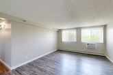 Located at 5021 Valley Lane in Streamwood, IL, this 2-bedroom, 2-bathroom unit offers a well-designed, single-floor layout that makes efficient use of its space. The open living room is bright and airy, featuring durable wood-style laminate flooring, neutral gray walls, a textured ceiling, and dual windows with vertical blinds that invite natural light and outdoor views of surrounding greenery. A wall-mounted A/C unit and baseboard heating ensure year-round comfort. The galley-style kitchen has been thoughtfully updated with gray shaker cabinets adorned with gold-tone hardware, granite-look countertops, a stainless steel sink, and stainless steel appliances including a gas range and refrigerator. Wood-style flooring continues seamlessly into the kitchen. Both bedrooms offer a quieter, carpeted retreat with neutral tones, baseboard heating, and windows providing natural light. The primary bedroom is generously sized, while the second bedroom offers comfortable space for guests or a home office. A dedicated closet provides additional storage. The bathrooms are clean and modern, featuring wood-style flooring, granite-topped vanities, and full tub-shower combinations with brushed nickel fixtures. A hallway connects all rooms, contributing to a cohesive and functional floor plan.