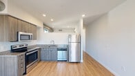 Located in Philadelphia's vibrant Fishtown neighborhood, this thoughtfully designed one-bedroom, one-bathroom unit offers a smart and efficient layout across a single floor. Light hardwood flooring runs throughout, creating a warm, cohesive feel from room to room.

The open-concept kitchen and living area serves as the heart of the unit. The kitchen is equipped with a full suite of stainless steel appliances — including a refrigerator, electric range, microwave, and dishwasher — complemented by granite countertops and wood-toned cabinetry. An exposed cylindrical duct adds an industrial design accent overhead, while recessed lighting keeps the space bright and functional.

The bedroom is a calm, well-lit retreat featuring multiple windows that invite generous natural light and offer views of the surrounding Fishtown streetscape. The clean, neutral walls provide a versatile backdrop.

The bathroom is finished with classic white subway tile surrounding the tub and shower, large-format floor tile, a granite-topped vanity with an undermount sink, and a wide mirror with built-in shelving. The hallway connecting the rooms features stylish barn-style sliding doors, adding character to the space. Additional amenities include a dedicated closet, in-unit laundry, and a utility room for added convenience.