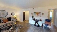 This single-story, two-bedroom, one-bathroom residence offers a thoughtfully arranged floor plan that maximizes functionality across its well-proportioned rooms. The living room features plush carpeting, neutral gray walls, and a sliding glass door that fills the space with natural light while providing direct access to a private outdoor patio. An adjacent dining area accommodates a full-sized table and is finished with wood-look flooring, a centered ceiling light fixture, and a window dressed with sheer curtains.

The kitchen is outfitted with rich, dark espresso cabinetry, granite-style countertops, a double stainless steel sink, and white appliances including a gas range and full-size refrigerator, offering ample storage and counter space throughout.

Both bedrooms are carpeted and feature windows that allow natural light to filter in. The primary bedroom is spacious enough to comfortably accommodate a full bed and additional furniture. The second bedroom offers flexibility as a guest room or home office.

The shared bathroom includes a dark vanity with a granite-style countertop, a single sink, and a tub/shower combination, maintaining the consistent, polished aesthetic found throughout the home.