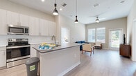 Located at 2035 Tapestry Park Drive in Indian Land, SC, this thoughtfully designed 2-bedroom, 3-bathroom residence offers a clean, contemporary aesthetic throughout its single-floor layout. The open-concept kitchen and living area serves as the heart of the home, featuring light wood-toned cabinetry, a subway tile backsplash, stainless steel appliances, and a central island with a quartz-style countertop and pendant lighting above. Light wood-style flooring flows through the main living areas, complementing the bright, neutral palette. The living room benefits from tall ceilings, a ceiling fan, and large windows that invite ample natural light and outdoor views. Both bedrooms are carpeted and well-proportioned, with the primary bedroom offering generous space, a ceiling fan, and a window with outdoor views. The secondary bedroom is bright and versatile, also featuring large windows. The three bathrooms are finished with light wood-toned vanities, white countertops, and marble-style tiled showers and tub surrounds. Each bathroom features wood-look flooring, adding warmth and continuity. A dedicated laundry room with in-unit washer and dryer connections rounds out this well-appointed residence, offering both comfort and practicality.