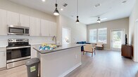 Located at 2035 Tapestry Park Drive in Indian Land, SC, this thoughtfully designed 2-bedroom, 3-bathroom residence offers a clean, contemporary aesthetic throughout its single-floor layout. The open-concept kitchen and living area serves as the heart of the home, featuring light wood-toned cabinetry, a subway tile backsplash, stainless steel appliances, and a central island with a quartz-style countertop and pendant lighting above. Light wood-style flooring flows through the main living areas, complementing the bright, neutral palette. The living room benefits from tall ceilings, a ceiling fan, and large windows that invite ample natural light and outdoor views. Both bedrooms are carpeted and well-proportioned, with the primary bedroom offering generous space, a ceiling fan, and a window with outdoor views. The secondary bedroom is bright and versatile, also featuring large windows. The three bathrooms are finished with light wood-toned vanities, white countertops, and marble-style tiled showers and tub surrounds. Each bathroom features wood-look flooring, adding warmth and continuity. A dedicated laundry room with in-unit washer and dryer connections rounds out this well-appointed residence, offering both comfort and practicality.