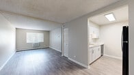 Located at 12154 W Nevada Dr in Lakewood, Colorado, this single-floor residence offers three bedrooms and two bathrooms within a well-organized layout. The living area features wood-style luxury vinyl flooring in a warm gray tone, neutral wall colors, textured ceilings, and a wall-mounted climate unit, with natural light filtering in through vertical-blind windows. The space flows openly toward a hallway that connects to the rest of the home. The galley-style kitchen is equipped with white shaker cabinetry, marble-look countertops, a stainless steel sink, dishwasher, and electric range with an overhead microwave, all set on light wood-style flooring. Two bathrooms feature updated white vanities with marble-look countertops and modern hardware. One bathroom provides access to a dedicated closet with built-in shelving. The three bedrooms are carpeted in a neutral beige tone and include textured ceilings, baseboard heating, and ample natural light. The primary bedroom offers a generous footprint, while the secondary bedrooms are well-proportioned. Bi-fold closet doors are present in at least one bedroom. A hallway connects the sleeping quarters, providing a functional and efficient flow throughout this clean, move-in ready Lakewood home.