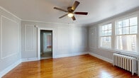 Located at 357 Morris St in Albany, NY, this single-floor, 3-bedroom, 1-bathroom unit offers a well-organized layout connecting bedrooms, a kitchen, bathroom, and hallway. Throughout the space, warm hardwood floors provide a consistent and inviting foundation, complemented by soft gray walls and crisp white trim. Crown molding and decorative wall paneling lend a classic architectural character to the rooms.

The spacious primary bedroom features elegant picture-frame wall molding, a ceiling fan with light fixture, and natural light from a double-hung window. The additional bedrooms also showcase hardwood floors, crown molding, ceiling fans, and natural light — one includes a traditional cast-iron radiator, highlighting the home's classic construction.

The kitchen is equipped with a gas range, refrigerator, and rich cherry wood cabinetry with crown molding detail above. Tile flooring and a practical layout make it a functional cooking space. Two interior doors lead to additional areas of the unit.

The bathroom features full white subway tile surrounding a tub-shower combo, classic black-and-white mosaic tile flooring, and a window providing natural ventilation and light. The overall ambiance of the unit is clean, bright, and defined by timeless architectural details consistent with Albany's historic residential character.