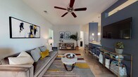 Located at 1500 Parklawn Dr in Charleston, South Carolina, this thoughtfully designed single-floor residence offers a cohesive blend of contemporary style and functional living. The open-concept main living area features light hardwood-style flooring, ceiling fans, and a bold navy accent wall that anchors the space. A built-in bar counter with pendant lighting connects the living room to the galley-style kitchen, which is equipped with dark cabinetry, granite countertops, stainless steel appliances, and track lighting overhead. The adjacent dining area is defined by a bay window framed with navy curtains, filling the space with natural light. Two well-appointed bedrooms each feature ceiling fans, plush carpeting, and large windows. The primary bedroom showcases a warm sage green accent wall, while the secondary bedroom features a deep navy accent wall, both offering a calm and restful atmosphere. Two full bathrooms are finished with tile flooring, dark vanity cabinetry, and tub-shower combinations. Throughout the residence, a consistent modern color palette, natural light, and carefully considered design details create a welcoming and stylish living environment in the heart of Charleston.