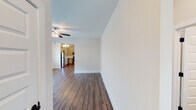 Located at 9001 Weaver Ave NE in Leeds, Alabama, this single-story home offers a clean, modern interior with a cohesive design throughout. Rich hardwood-style flooring flows seamlessly across the entire residence, providing a warm and uniform aesthetic in every room.

The living area is generously sized and filled with natural light from multiple windows fitted with white blinds. A ceiling fan overhead adds practical comfort, while an open passageway connects the living space directly to the kitchen, creating an open and airy layout.

The kitchen is well-appointed with grey cabinetry, light granite-style countertops, and a full suite of stainless steel appliances including a range, over-the-range microwave, dishwasher, and refrigerator. Recessed lighting and a secondary door provide added functionality and convenience.

The bedrooms are comfortably sized with neutral toned walls, ceiling fans, and windows that invite natural light. Each room offers a calm, versatile space suitable for a variety of uses.

The bathrooms are finished in a clean, all-white palette, each featuring a tub-shower combination, toilet, and vanity with a white countertop. Chrome fixtures and towel bars complete the tidy, functional design. Overall, the home presents a bright, move-in-ready environment with consistent finishes throughout.