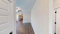 Located at 9001 Weaver Ave NE in Leeds, Alabama, this single-story home offers a clean, modern interior with a cohesive design throughout. Rich hardwood-style flooring flows seamlessly across the entire residence, providing a warm and uniform aesthetic in every room.

The living area is generously sized and filled with natural light from multiple windows fitted with white blinds. A ceiling fan overhead adds practical comfort, while an open passageway connects the living space directly to the kitchen, creating an open and airy layout.

The kitchen is well-appointed with grey cabinetry, light granite-style countertops, and a full suite of stainless steel appliances including a range, over-the-range microwave, dishwasher, and refrigerator. Recessed lighting and a secondary door provide added functionality and convenience.

The bedrooms are comfortably sized with neutral toned walls, ceiling fans, and windows that invite natural light. Each room offers a calm, versatile space suitable for a variety of uses.

The bathrooms are finished in a clean, all-white palette, each featuring a tub-shower combination, toilet, and vanity with a white countertop. Chrome fixtures and towel bars complete the tidy, functional design. Overall, the home presents a bright, move-in-ready environment with consistent finishes throughout.