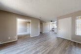 Located at 1250 S Cawston Ave in Hemet, California, this single-story, 3-bedroom, 2-bathroom home offers a practical and well-organized layout. The combined living and dining area is spacious and open, featuring wood-look vinyl plank flooring, neutral taupe walls, a textured ceiling, and a ceiling fan. A sliding glass door connects the living area to an outdoor space, allowing natural light to flow in. The kitchen is outfitted with white cabinetry, granite-look countertops, a dishwasher, and recessed lighting, complemented by a side window that brightens the workspace. The three bedrooms include a generously sized primary bedroom; the bedrooms feature plush carpeting, neutral tones, and ample closet space with sliding doors. A hallway connects the private quarters, providing clear separation from the main living areas. The two bathrooms are finished with wood-look vinyl flooring — one includes a tub-shower combination with a vanity, while the other features a standalone walk-in shower. A dedicated laundry area adds everyday convenience. With four closets throughout, this home offers practical storage solutions across every room.