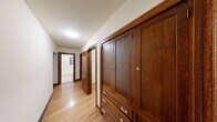Located in the desirable Queen Anne neighborhood of Seattle, this single-floor residence at 900 Queen Anne Ave N, Unit 301, offers a well-organized layout with classic architectural details throughout. Warm hardwood flooring extends across the living and bedroom areas, complemented by rich dark wood trim that frames the windows and doorways, lending a traditional and cohesive character to the space.

The bedrooms are generously proportioned, each featuring hardwood floors and wood-trimmed windows that bring in natural light and offer views of surrounding greenery and the neighborhood streetscape. One bedroom includes a closet with built-in shelving, while another benefits from multiple windows on adjacent walls, creating a bright and airy atmosphere.

The hallway is a standout feature, lined with substantial built-in dark wood cabinetry complete with paneled doors and crystal-style hardware — providing ample storage while adding a refined, craftsman-inspired aesthetic. The hallway leads to a bathroom visible at the far end.

The kitchen is efficiently designed with warm wood cabinetry on both sides, light-toned countertops, and classic hexagonal tile flooring. It is equipped with a range, overhead microwave, refrigerator, and a sink, along with glass-front upper cabinets that add a touch of openness. The overall ambiance of the unit is warm, functional, and rooted in timeless residential design.