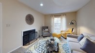 This single-story residence offers a comfortable and functional layout across several well-defined spaces. The living room serves as the heart of the home, anchored by a classic fireplace with an arched screen and decorative surround. Natural light filters in through a sliding glass door dressed with patterned curtains, and a sunburst wall accent adds a decorative focal point. Ceiling fans are present throughout, contributing to a consistent, practical design language.

The kitchen features white cabinetry, granite-style laminate countertops, and a white electric range with an overhead exhaust hood. A mirrored backsplash detail adds subtle depth to the cooking area.

Multiple bedrooms provide versatile sleeping arrangements, each finished with carpet flooring and ceiling fans with light kits. The rooms feature neutral wall tones and window treatments that allow for natural light while maintaining privacy.

Two full bathrooms mirror each other in design, each equipped with a single-sink vanity topped with granite-style counters, white cabinetry, and a shower-tub combination. Dark wood-framed mirrors and textured walls complete the bathrooms' cohesive aesthetic. The overall ambiance of the residence is warm, neutral, and move-in ready.