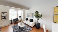 This multi-floor residence spans three levels and is designed with a clean, contemporary aesthetic that carries consistently throughout each space. Warm hardwood-style flooring flows through the main living areas, complementing the neutral wall tones and modern furnishings.

The living room is a bright, open space featuring large windows that invite natural light and offer outdoor views. Notably high angled ceilings add architectural character, and the room provides ample space for comfortable seating arrangements.

The kitchen is well-equipped with stainless steel appliances, including a refrigerator, range, and built-in microwave. Light wood cabinetry pairs with dark granite countertops and a classic subway tile backsplash, creating a practical yet polished cooking environment. A large window brings in additional natural light.

The bedrooms are generously sized, each featuring ceiling fans, large windows with outdoor views, and hardwood-style flooring. The primary bedroom includes direct access to an en-suite bathroom, while additional bedrooms offer flexible use of space.

The bathrooms are finished with wood-tone vanities, white countertops, tiled tub-shower combinations, and large mirrors, maintaining the residence's consistent, clean design language throughout.