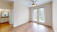 Located at 1300 Hendricks Ave in Jacksonville, FL, this single-floor, 2-bedroom, 2-bathroom residence offers a thoughtfully designed layout with modern finishes throughout. The open-concept kitchen is a standout feature, showcasing crisp white cabinetry, granite countertops, a subway tile backsplash, stainless steel appliances including a French door refrigerator and electric range, and a peninsula with pendant lighting — ideal for both cooking and casual dining. Warm hardwood-style flooring flows through the main living areas and bathrooms, while plush carpet adds comfort to the bedrooms. The living area is bright and airy, featuring French doors that invite natural light and open views of the surrounding neighborhood. Both bedrooms are generously proportioned, each equipped with ceiling fans, large windows, and dedicated walk-in closets with wire shelving systems for ample storage. The bathrooms are finished with granite-topped white vanities, framed mirrors, and glass-enclosed showers. Clean, neutral wall tones and recessed lighting throughout lend the space a contemporary, move-in-ready feel. This residence combines functional design with quality finishes in a convenient Jacksonville location.