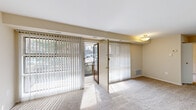 This 2-bedroom, 1-bathroom residence offers a practical and well-organized single-floor layout highlighted by distinctive parquet wood flooring that runs consistently throughout every room. The spacious living room is a central feature, showcasing a ceiling fan, large sliding glass doors fitted with vertical blinds, and direct access to a private balcony that provides open outdoor views of the surrounding landscape. Natural light flows generously into the space through multiple windows and the glass balcony doors.

The kitchen is positioned adjacent to the living area and connects efficiently to the hallway. Both bedrooms continue the parquet flooring theme and feature windows with natural views of nearby trees. Each bedroom is equipped with its own closet, offering dedicated storage, while an additional third closet provides extra organizational space. The primary bedroom is a comfortable size with ample room for furnishings.

The bathroom is clean and functional, featuring white subway tile surrounding a tub-shower combination, a vanity with under-sink cabinet storage, a mirrored medicine cabinet, and a well-lit overhead light bar. The neutral color palette throughout the residence — warm beige walls paired with white trim — creates a consistent, understated aesthetic that allows for versatile interior customization.