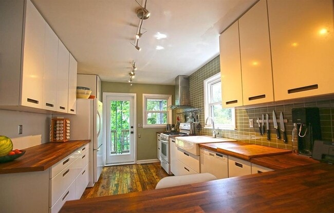 The kitchen has been lovingly updated with Maple countertops, a Breakfast Bar with seating for 4, a white Farm Sink, subway tile backsplash AND soft-close IKEA Cabinets - 903 Highland Rd