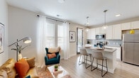 Located at 80 S 18th St. in Columbus, OH, this thoughtfully designed one-bedroom, one-bathroom residence offers a modern and comfortable living experience. The open-concept layout seamlessly connects the living room and kitchen, maximizing the efficient use of space while maintaining an airy, welcoming atmosphere. Large windows dressed with sheer white curtains flood the living area with abundant natural light, complementing the light wood-style flooring that runs throughout the main living spaces.

The kitchen is well-appointed with white shaker cabinetry, granite countertops, a subway tile backsplash, and a full suite of stainless steel appliances, including a range, microwave, and refrigerator. A peninsula with bar seating provides a convenient dining and entertaining area.

A clean, well-lit hallway with dark-paneled doors leads to the private quarters. The bedroom features soft carpeting, neutral walls, and direct access to a dedicated closet with a full rod and shelving system. The bathroom includes a granite-topped vanity, a tub-shower combination, and wood-style flooring that ties the space together cohesively.

The unit's neutral color palette, consistent finishes, and efficient floor plan create a polished, move-in-ready environment suited for comfortable urban living in Columbus's dynamic South Side neighborhood.