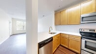 Located at 40 East Hanover Avenue in Morris Plains, NJ, this well-appointed one-bedroom, one-bathroom residence offers a thoughtfully designed single-floor layout. Rich hardwood flooring flows throughout, complementing the clean, neutral color palette that gives the space a bright and airy feel. The open-concept living and dining area is generously sized, bathed in natural light through large windows with tree-lined views, and connects seamlessly to a private balcony — ideal for outdoor relaxation. The kitchen is efficiently laid out in an L-shape, featuring warm honey-toned wood cabinetry with gold hardware, white quartz countertops, a herringbone tile backsplash, a gold-tone pull-down faucet, and a full suite of stainless steel appliances including a dishwasher, electric range, and built-in microwave. A dedicated hallway leads to the spacious bedroom, which includes a large window with greenery views, providing a calm and private retreat. Two closets offer ample storage throughout the unit. The bathroom features crisp white cabinetry and clean finishes. A functional hallway connects all areas of the residence, completing this cohesive and move-in-ready home.