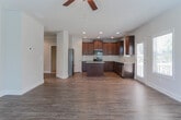 Located at 50 MacLand Township Dr in Dallas, GA, this three-floor home offers a thoughtfully designed layout spread across multiple levels. The entryway greets visitors with rich hardwood-style flooring and a staircase adorned with warm wood handrails and decorative wrought iron balusters, setting an inviting tone throughout.

The main level features recessed lighting, crown molding, and hardwood-style floors that extend through the hallways and living areas. The kitchen is well-equipped with rich dark wood cabinetry, a granite-topped center island, stainless steel appliances including a refrigerator, range, and built-in microwave, along with a classic subway tile backsplash and a walk-in pantry for generous storage.

Upstairs, the primary bedroom impresses with soaring vaulted ceilings and plush carpeting, connecting directly to an en-suite bathroom that includes both a separate glass-enclosed shower and a soaking tub with natural window light. Additional bedrooms are carpeted and naturally lit. A secondary full bathroom features a combination tub and shower with dark wood vanity cabinetry. A spacious walk-in closet with wire shelving adds practical storage.

The lower level presents an unfinished basement with concrete walls, exposed framing, and rough-in plumbing, offering significant potential for customization or expansion.