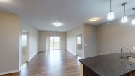 Located at 3111 43rd Ave NE in Bismarck, North Dakota, this single-floor unit offers a thoughtfully designed layout with a cohesive blend of modern finishes throughout. The open-concept living and dining area is anchored by durable wood-style plank flooring that extends through the main living spaces, while neutral-toned walls and flush-mount lighting create a clean, welcoming atmosphere. A sliding glass door leads to a private balcony, bringing in natural light and views of the surrounding neighborhood.

The kitchen is equipped with dark espresso cabinetry, dark granite countertops, stainless steel appliances including a refrigerator and microwave, and pendant lighting above the counter, adding a polished touch. An in-unit laundry area is conveniently accessible from the kitchen corridor.

The bedrooms feature plush carpeting and windows that provide natural light and neighborhood views, offering comfortable, quiet retreats. Two bathrooms serve the unit, each finished with dark granite vanity tops, rich espresso cabinetry, undermount sinks, and a tub/shower combination, maintaining a consistent design aesthetic. The overall ambiance is modern, clean, and functional, suited for everyday living.
