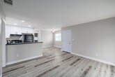Located at 1825 E Valley Pkwy in Escondido, CA, this single-story 3-bedroom, 2-bathroom home offers a clean, modern aesthetic throughout. Light-toned vinyl plank flooring flows seamlessly across the entire floor plan, creating a cohesive and bright interior.

The kitchen is a standout feature, showcasing crisp white shaker cabinetry with black hardware, light quartz countertops, a stainless steel sink, and black stainless appliances including a gas range and refrigerator. The kitchen opens toward the dining and living areas, supporting an efficient and connected layout.

The living room is bathed in natural light, featuring sliding glass doors fitted with vertical blinds that lead directly to a private balcony—ideal for enjoying the Southern California climate. The neutral warm-beige walls throughout the home complement the light flooring and create a calm, welcoming atmosphere.

Each of the three bedrooms is well-proportioned, filled with natural light from large windows with blinds, and features ample closet space with sliding frosted-panel closet doors. The primary bedroom offers a generous footprint with direct balcony access. Both bathrooms are functional and neatly finished, each equipped with a full tub-shower combination. A hallway connects all rooms, and four closets provide excellent storage throughout.