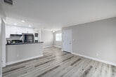 Located at 1825 E Valley Pkwy in Escondido, CA, this single-story 3-bedroom, 2-bathroom home offers a clean, modern aesthetic throughout. Light-toned vinyl plank flooring flows seamlessly across the entire floor plan, creating a cohesive and bright interior.

The kitchen is a standout feature, showcasing crisp white shaker cabinetry with black hardware, light quartz countertops, a stainless steel sink, and black stainless appliances including a gas range and refrigerator. The kitchen opens toward the dining and living areas, supporting an efficient and connected layout.

The living room is bathed in natural light, featuring sliding glass doors fitted with vertical blinds that lead directly to a private balcony—ideal for enjoying the Southern California climate. The neutral warm-beige walls throughout the home complement the light flooring and create a calm, welcoming atmosphere.

Each of the three bedrooms is well-proportioned, filled with natural light from large windows with blinds, and features ample closet space with sliding frosted-panel closet doors. The primary bedroom offers a generous footprint with direct balcony access. Both bathrooms are functional and neatly finished, each equipped with a full tub-shower combination. A hallway connects all rooms, and four closets provide excellent storage throughout.