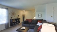 Located at 3300 West Dublin Granville Road in Columbus, Ohio, this two-story residence offers a practical and inviting layout designed for comfortable everyday living. The main level features a spacious living area with light-toned walls, a textured ceiling, and soft carpeted flooring that adds warmth underfoot. The living room is generously sized, providing ample space for seating arrangements centered around a coffee table, making it well-suited for both relaxing and entertaining. A staircase with a white railing rises from the main living area, connecting seamlessly to the upper floor and serving as a natural architectural focal point within the room. Decorative wall accents and thoughtful lighting contribute to the welcoming ambiance of the main level. The overall interior aesthetic is clean and understated, with neutral tones throughout that create a versatile backdrop. Situated in Columbus's northwest corridor, the property benefits from convenient access to local amenities, shopping, and major roadways. Spanning two floors, the home provides a clear separation between living and private spaces, offering both functionality and a sense of spaciousness throughout.