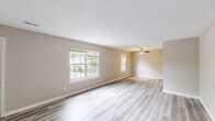 Located at 2 S Kingsbridge Pl in Chesapeake, VA, this single-story, 3-bedroom, 2-bathroom home offers a thoughtfully designed layout with clean, modern finishes throughout. Light-toned luxury vinyl plank flooring flows consistently across the entire home, complementing the neutral warm-beige wall palette and crisp white trim.

The living room is bright and welcoming, with multiple windows that invite natural light and views of the surrounding greenery. A ceiling fan adds comfort to the space, which opens toward the dining area and kitchen. The kitchen is well-equipped, featuring white shaker-style cabinetry, granite-look countertops, stainless steel appliances including a range and dishwasher, and a pantry for added storage.

The generously sized primary bedroom offers a walk-in closet. The two additional bedrooms are comfortably sized, each with access to ample closet space — the home includes six closets in total. Both bathrooms are finished with white cabinetry, granite-look counters, and tub-shower combinations with brushed nickel fixtures.

A dedicated laundry room and hallway complete the functional floor plan. The home's consistent finishes, abundant storage, and well-distributed natural light create a clean, move-in-ready living environment.