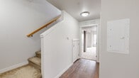 Located at 5601 Gordon Rd in Regina, Saskatchewan, this two-bedroom, one-bathroom unit offers a practical and well-organized layout across a single floor. The entry hallway sets a clean, neutral tone with crisp white walls, dark hardwood-style flooring, and a carpeted staircase with a warm wood handrail. Overhead lighting and a ventilation unit above the doorway add functional detail to the corridor, which leads naturally through the space.

The primary bedroom is generously sized, offering ample room for furnishings, and is finished with soft wall-to-wall carpet that adds warmth underfoot. Natural light filters in through a sidelight window in the second bedroom, which also features carpet flooring, a built-in closet, and clean white walls throughout. Both rooms share the same neutral palette, creating a calm and versatile living environment.

A dedicated closet space features wire shelving for organized storage, complementing the practical nature of the unit. The bathroom is equipped with a full-sized soaker tub and shower combo, finished in clean white with chrome fixtures — simple and functional in design.

Overall, this unit presents a tidy, move-in-ready space with consistent finishes, efficient use of space, and a bright, neutral aesthetic well-suited to comfortable everyday living.