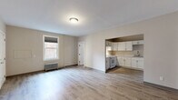 Located at 1101 Elm St in Manchester, NH, this one-bedroom, one-bathroom residence offers a clean, updated interior with a practical and well-organized layout. Light-toned vinyl plank flooring runs consistently throughout the unit, providing a cohesive and easy-to-maintain finish underfoot.

The open living area is bright and welcoming, featuring neutral walls, a classic cast-iron radiator, and a window that invites natural light. It flows directly into the kitchen, which is well-appointed with white shaker-style cabinetry, marble-pattern countertops, a stainless steel sink, and white appliances including a gas range and full-size refrigerator — offering ample storage and prep space.

The spacious bedroom features warm wood-tone flooring, a built-in open closet, and a dedicated door for privacy. It offers a comfortable, versatile layout suitable for a variety of furniture arrangements.

The bathroom is neatly finished with a white vanity, medicine cabinet mirror, toilet, and a full-size soaking tub with shower, all set against neutral walls and matching vinyl flooring.

Throughout the unit, the neutral color palette, consistent flooring, and clean finishes contribute to a calm, functional atmosphere well-suited for everyday living in the heart of Manchester.