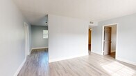 Located at 2280 Mayfair Way in Titusville, Florida, this single-story home presents a clean, updated interior with a cohesive neutral color palette and light-toned luxury vinyl plank flooring that flows throughout the entire space. The open layout connects the living areas seamlessly, with natural light filtering through multiple windows dressed with white blinds, brightening each room with a fresh, airy feel.

The kitchen is a standout feature, outfitted with crisp white shaker-style cabinetry, granite-look countertops, a stainless steel sink with a modern faucet, and stainless steel appliances including a refrigerator and electric range. A textured ceiling adds subtle dimension overhead, while HVAC vents are thoughtfully integrated throughout.

The living and entry areas are generously proportioned, with smooth, soft-gray walls and clean white baseboards that give the space a polished, move-in-ready appearance. Multiple rooms offer flexible use, each featuring the same consistent flooring and neutral tones, along with windows that provide natural light and ventilation.

The bathroom includes a full soaking tub framed by classic white subway tile surround and a frosted privacy window. Closets with paneled doors add practical storage. The overall design is functional, clean, and well-maintained, offering a comfortable and versatile living environment.