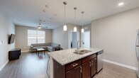 Located at 801 W 4th Ave in Stillwater, Oklahoma, this well-designed unit offers four bedrooms and four bathrooms across a thoughtfully laid-out single floor. The open-concept kitchen and living area serves as the heart of the home, where rich dark wood cabinetry pairs with a striking granite-topped island — complete with bar seating and pendant lighting — to create an inviting, functional space. Stainless steel appliances, a subway tile backsplash, and recessed lighting add a polished, contemporary feel. The living room features durable wood-style flooring, a wall-mounted TV setup, and a ceiling fan with light fixture, with natural light streaming in through large windows fitted with blinds. Each of the four bedrooms is carpeted for comfort, equipped with a ceiling fan, and includes a closet with double doors. Several bedrooms feature private or adjacent bathrooms, each outfitted with a full tub-shower combination, chrome fixtures, and wood-style flooring. The neutral color palette throughout lends a clean, modern aesthetic, while the consistent finishes across rooms create a cohesive living environment well-suited for shared occupancy.