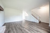Located at 5 Singleton Ct in Madison, WI, this two-bedroom, two-bathroom residence spans three floors, offering a well-organized and functional layout. The main level features an open-concept kitchen and living area, where rich hardwood-style flooring flows throughout. The kitchen is outfitted with dark wood cabinetry, granite-look countertops, and stainless steel appliances including a refrigerator, dishwasher, and range. The adjoining living room is anchored by a striking full-height brick fireplace with a wood mantle, adding warmth and character to the space. A large window invites natural light and provides views of the surrounding neighborhood. Additional living space on a secondary level also features hardwood-style flooring, a ceiling fan, and bright vertical blinds. Both bedrooms are carpeted and offer a quiet, comfortable atmosphere, each with closet storage and windows providing natural light. The primary bedroom includes an en-suite connection to a well-appointed bathroom featuring a soaking tub with glass enclosure, marble-look tile surround, wood vanity, and hardwood-style flooring. A second bathroom provides a clean white vanity with a large mirror. Utility rooms and multiple staircases complete this thoughtfully arranged multi-level home.