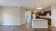 Located in Fort Worth, TX, this well-appointed single-story home offers three bedrooms, two bathrooms, and a thoughtfully designed layout. The open-concept living area flows seamlessly into the dining space and kitchen, which serves as the heart of the home. The kitchen is outfitted with rich dark wood cabinetry, granite countertops, stainless steel appliances including a refrigerator, range, and microwave, and a central island with pendant lighting overhead — ideal for both cooking and entertaining.

The living and dining areas feature durable hardwood-style flooring and are bathed in natural light from large windows and French doors that open to an outdoor view. Ceiling fans in the main living areas and bedrooms add comfort throughout.

The spacious primary bedroom offers plush carpet flooring, a ceiling fan, and generous natural light from multiple windows. It is complemented by a walk-in closet fitted with wire shelving for ample storage. The additional bedrooms also feature carpet and closet access connected by a carpeted hallway.

The bathrooms are finished with granite-topped vanities and dark wood cabinetry, with one featuring a tiled tub-shower combination. Neutral gray and beige tones throughout create a clean, cohesive aesthetic suited to a variety of décor styles.