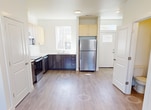 Located at 1043 Tartarian Ave in Richland, WA, this two-story home offers 1,070 square feet of thoughtfully arranged living space across two floors. The ground floor encompasses 420 square feet and features a bright, open entryway with recessed lighting, light wood-tone LVP flooring, and large windows that allow ample natural light. The modern kitchen is a standout feature, equipped with stainless steel appliances including a range, microwave, dishwasher, and refrigerator. Two-tone cabinetry pairs light upper cabinets with darker lower units, complemented by clean countertops and a window above the sink. The upper floor spans 650 square feet and houses all three bedrooms and two full bathrooms. The primary bedroom measures 110 square feet, and bedrooms feature sliding double-panel closet doors and large windows with neighborhood views. Both bathrooms include full tub-shower combinations with curtain rods, toilets, and vanities — one with brushed nickel hardware accents. Consistent light wood-tone flooring flows throughout the home, and neutral white walls create a clean, versatile aesthetic. A staircase and two hallways connect the floors, ensuring efficient circulation throughout this well-designed residential property.