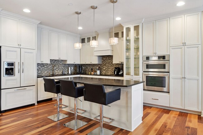 Kitchen features tiled backsplash, plenty of cabinet space for storage, and a pretty glass display - 875 Lake St N