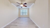 Located at 217 Tabor St in Clemson, SC, this single-floor home offers a clean, well-maintained interior with a thoughtfully designed layout. The kitchen is a standout feature, showcasing rich warm-toned wood cabinetry, granite countertops, and a full suite of stainless steel appliances including a range, over-the-range microwave, and refrigerator. A skylight adds a bright, airy quality to the kitchen space. The adjoining dining area is accented by an elegant chandelier and flows seamlessly into the main living areas, all tied together by neutral warm tones and crown molding throughout. Flooring transitions between large-format tile in the kitchen, dining, and bathrooms, and light wood-look laminate in the bedrooms and living spaces, creating visual continuity. The bedrooms are generously sized with ample natural light. The bathrooms feature the same tile flooring and include a full tub and shower combination; one bathroom also includes a granite-topped vanity with warm wood cabinetry. A dedicated laundry room is outfitted with utility connections, wire shelving, and tile flooring. The home's neutral color palette, crown molding, and consistent finishes throughout give it a polished and move-in ready appearance.